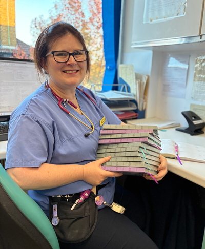 Midwife Faith Meaney with her NIPE notebooks