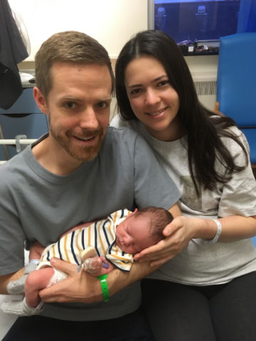 A couple holding a baby