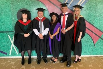 Picture of staff from teh Medical Edication Centre, in university style gowns