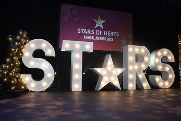 The word Stars standing on a dark stage