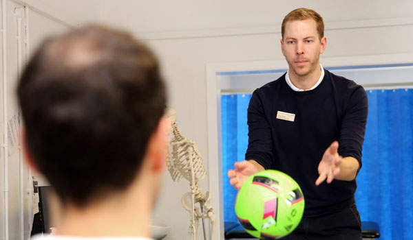 Picture of a physiotherapist throwing a ball to a patient