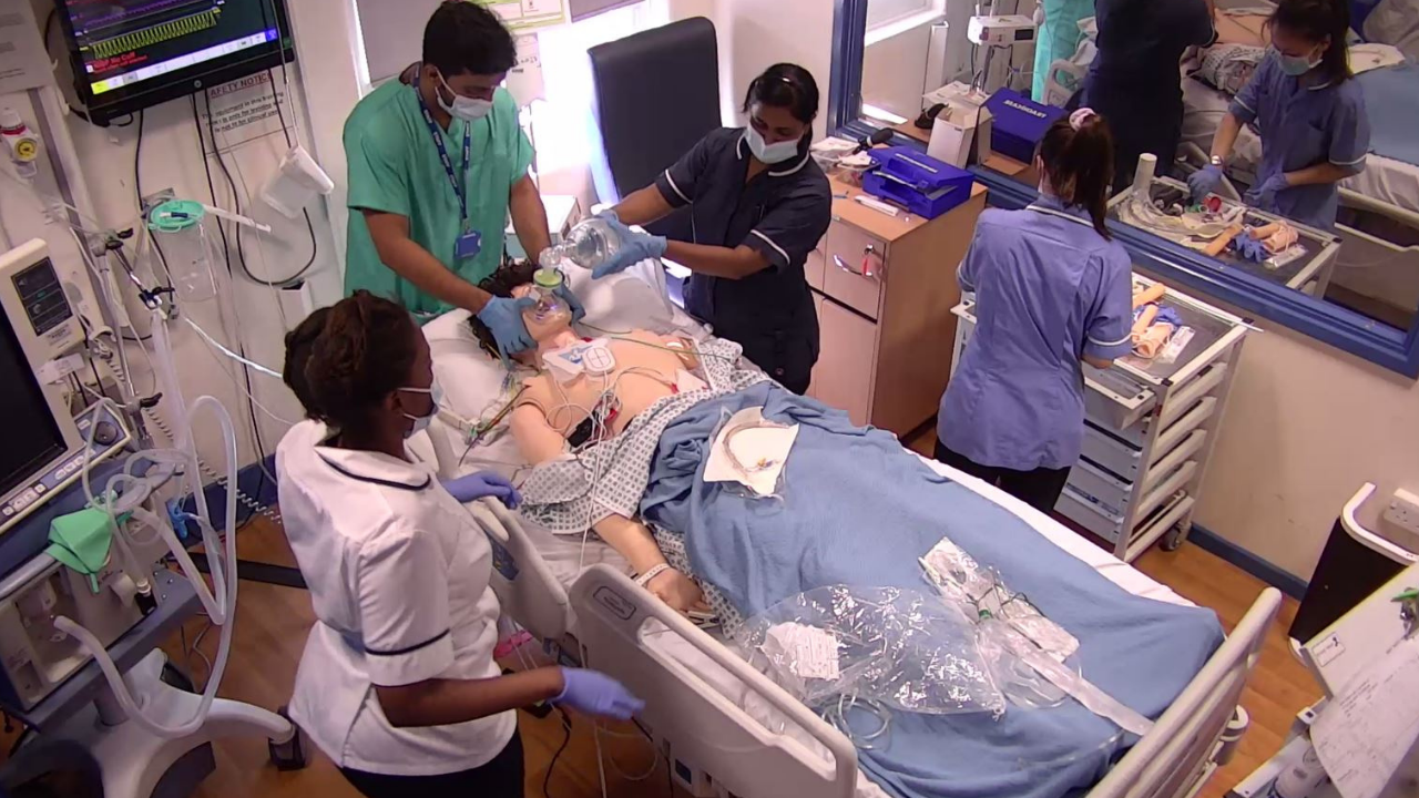 This picture shows a multi disciplinary group taking part in an intensive care simulation training session.