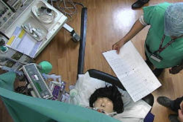 picture of an anaesthetic scenario showing two doctors reviewing a chart next to an anaesthetic machine